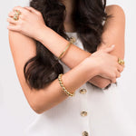 Model showcasing Divina Polished Beaded Gold Bangle and gold rings, highlighting elegant wrist accessories.