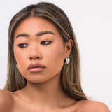 Model wearing Lyra Sculpted Mini Hoops, showcasing their modern, organic design and molten-inspired finish.