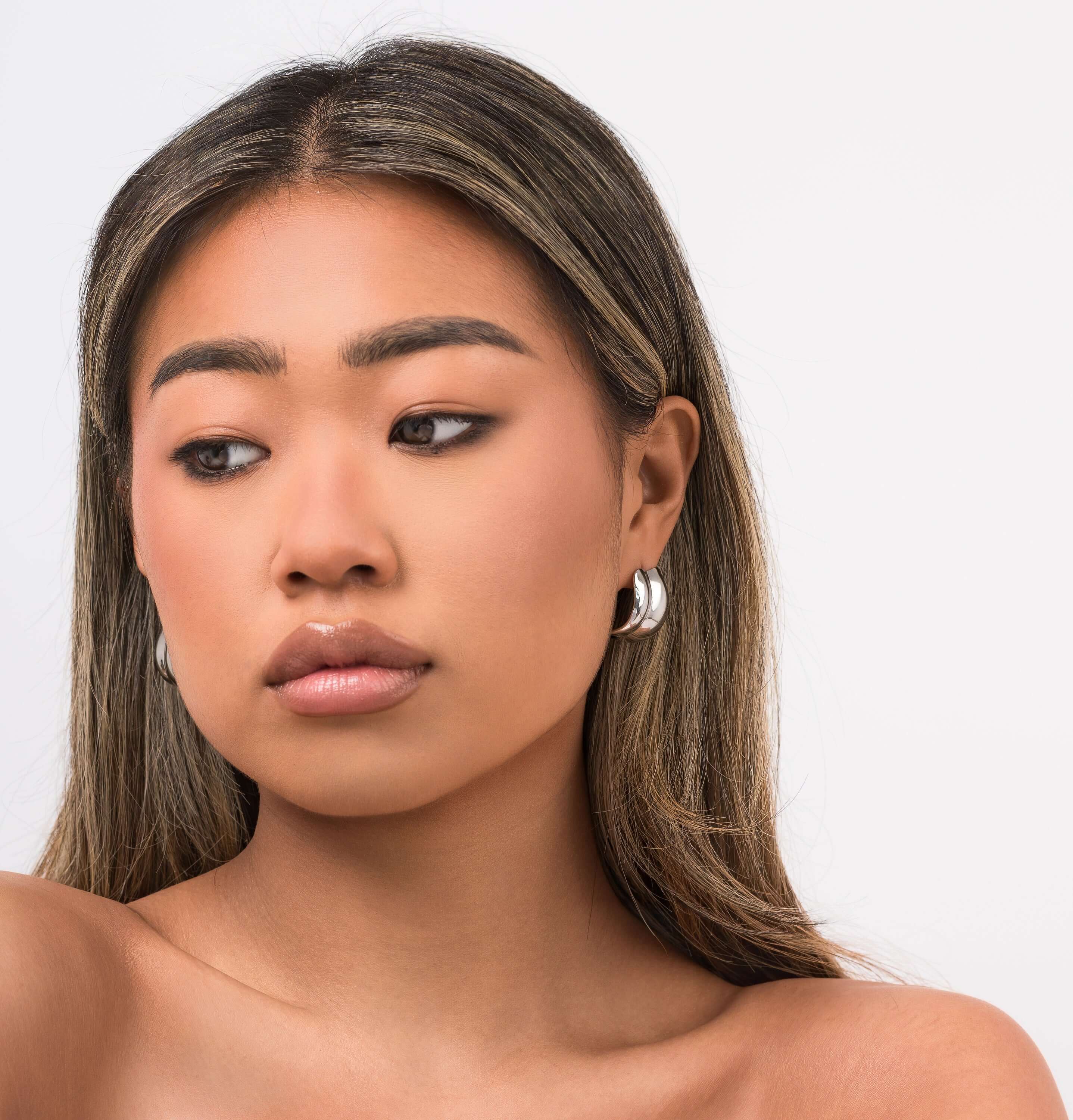 Model wearing Lyra Sculpted Mini Hoops, showcasing their modern, organic design and molten-inspired finish.