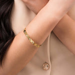 Ameera Lattice Engraved Gold Bangle Bracelet worn on a woman's wrist, showcasing its elegant crisscross design.