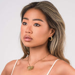 Elara Radiant Sunburst Pendant Necklace worn by a model, showcasing crystal detail and radiant spikes.