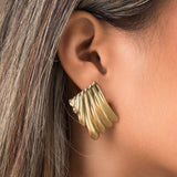 Gold Freya Sculpted Wave Hoops by ARIIRA, showcasing rhythmic ridged design in elegant silhouette.