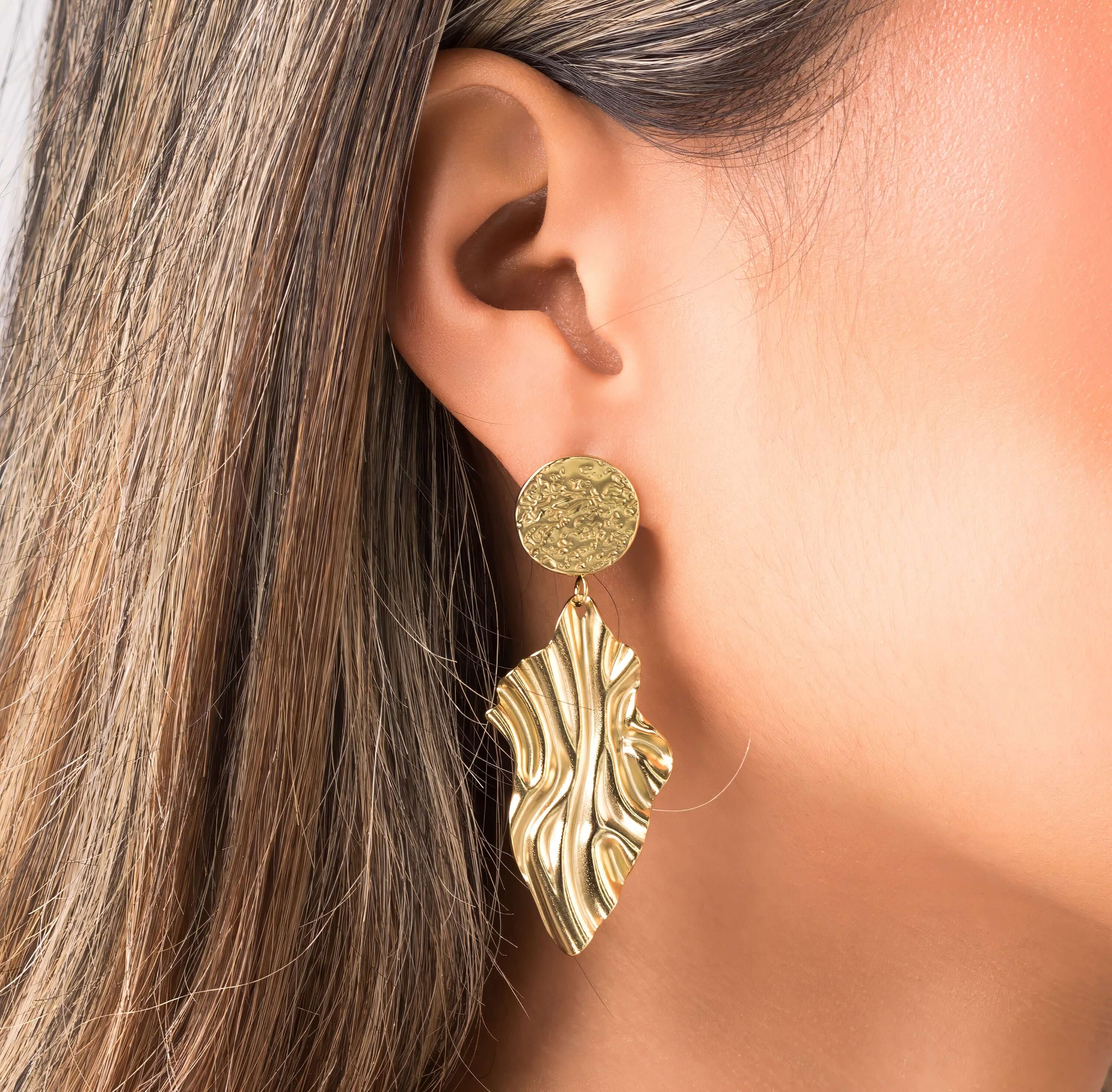 Layla Textured Drop Statement Earrings by ARIIRA with hammered disc and sculptural leaf design in gold.