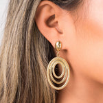 Elena Orbit Drop Earrings by ARIIRA showcasing sculptural gold curves for a modern and elegant look.