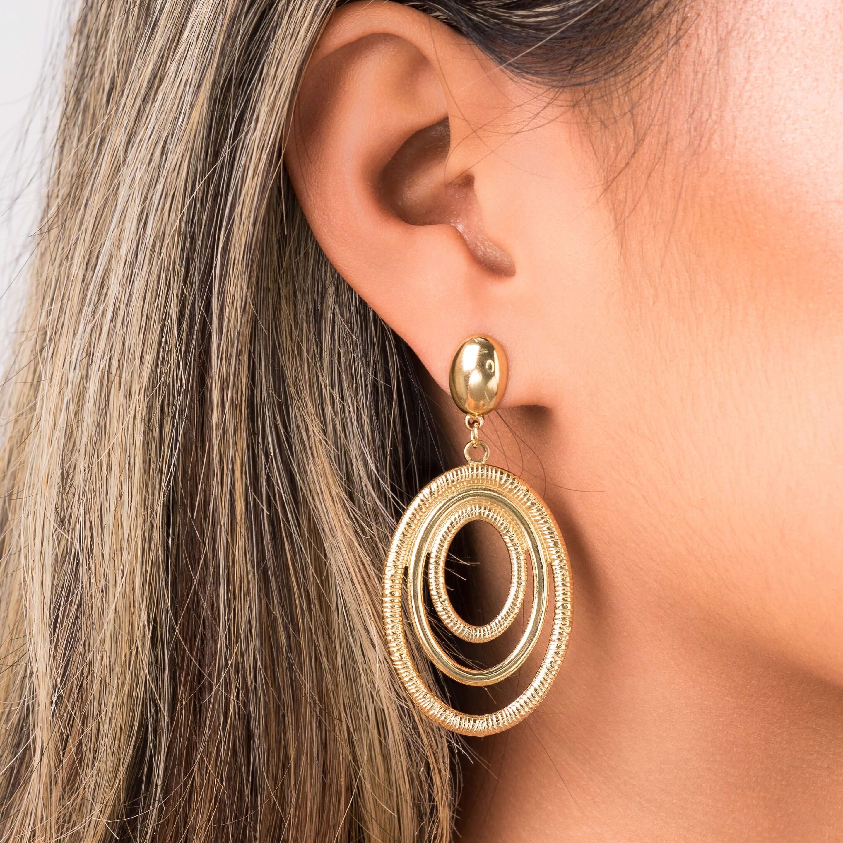 Elena Orbit Drop Earrings by ARIIRA showcasing sculptural gold curves for a modern and elegant look.