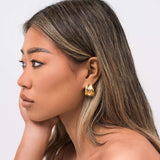 Model wearing ARIIRA Lyra Sculpted Mini Hoops showcasing their modern design and molten-inspired finish.