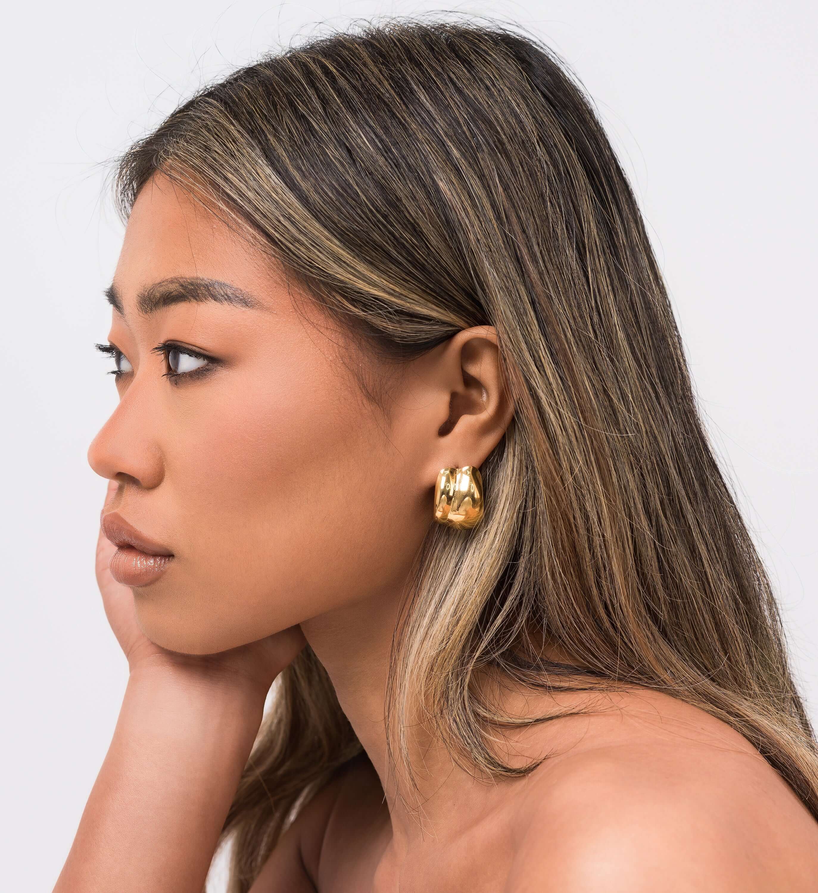 Model wearing ARIIRA Lyra Sculpted Mini Hoops showcasing their modern design and molten-inspired finish.