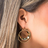 Close-up of a model wearing ARIIRA Noor Double Hoop Statement Earrings in polished gold, showcasing their elegant design.