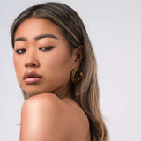 Woman wearing ARIIRA Noor Double Hoop Statement Earrings, showcasing a modern and elegant look with a light and polished design.