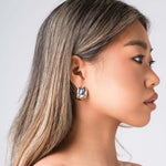 Model wearing ARIIRA Lyra Sculpted Mini Hoops, showcasing their smooth curves and modern design.
