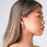 Model wearing ARIIRA Lyra Sculpted Mini Hoops, showcasing their smooth curves and modern design.
