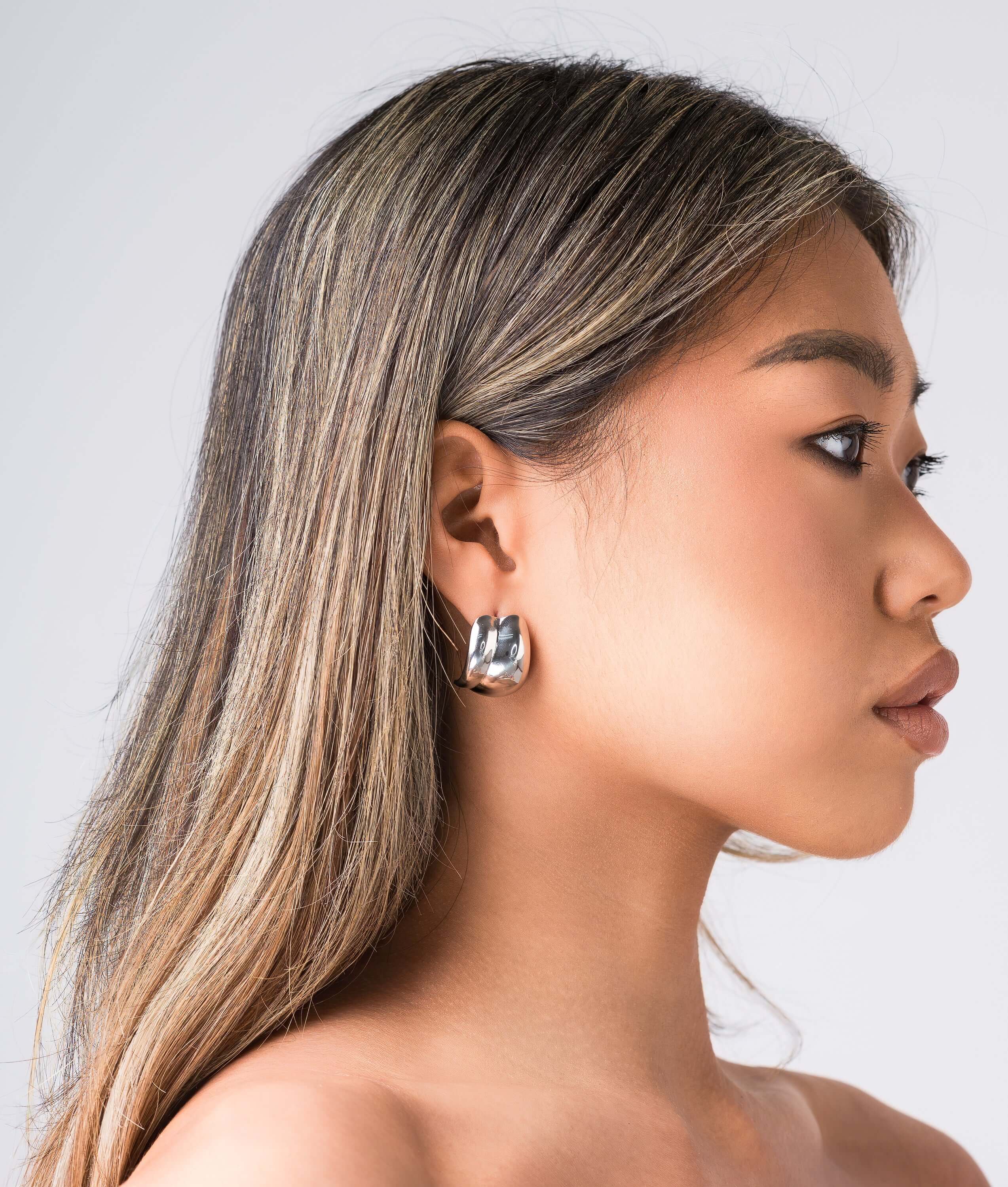 Model wearing ARIIRA Lyra Sculpted Mini Hoops, showcasing their smooth curves and modern design.