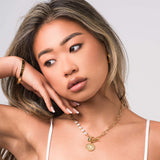 Model showcasing the ARIIRA Mira Pearl Link Medallion Necklace with freshwater pearls and gold chain links.