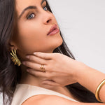 Model showcasing Zehra Textured Spiral Wrap Ring and bold gold earrings from ARIIRA, emphasizing modern women's jewelry.