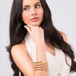 Model showcasing the ARIIRA Zina Spiral Mesh Coil Bracelet, featuring a soft spiral design and polished end spheres.