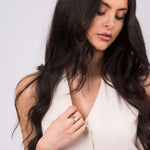 Woman wearing ARIIRA Kaia Triple Tone Crystal Ring Set featuring rose, gold, and silver bands with crystals.
