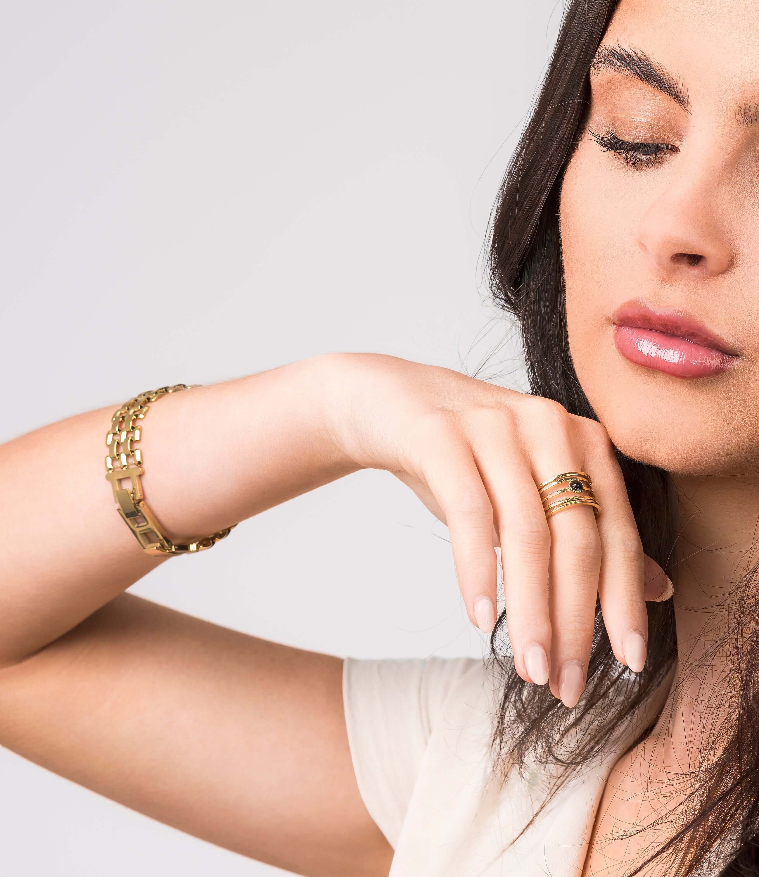 Model showcasing the Lena Layered Black Stone Ring by ARIIRA, featuring a bold design with a black stone and gold band.