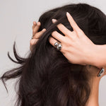 Woman showcasing the Inaya Sculptural Open Dome Ring with polished finish while styling her hair.