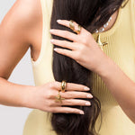 Woman wearing ARIIRA Mira Starfish Adjustable Ring with gold jewelry, showcasing coastal-inspired style and elegance.