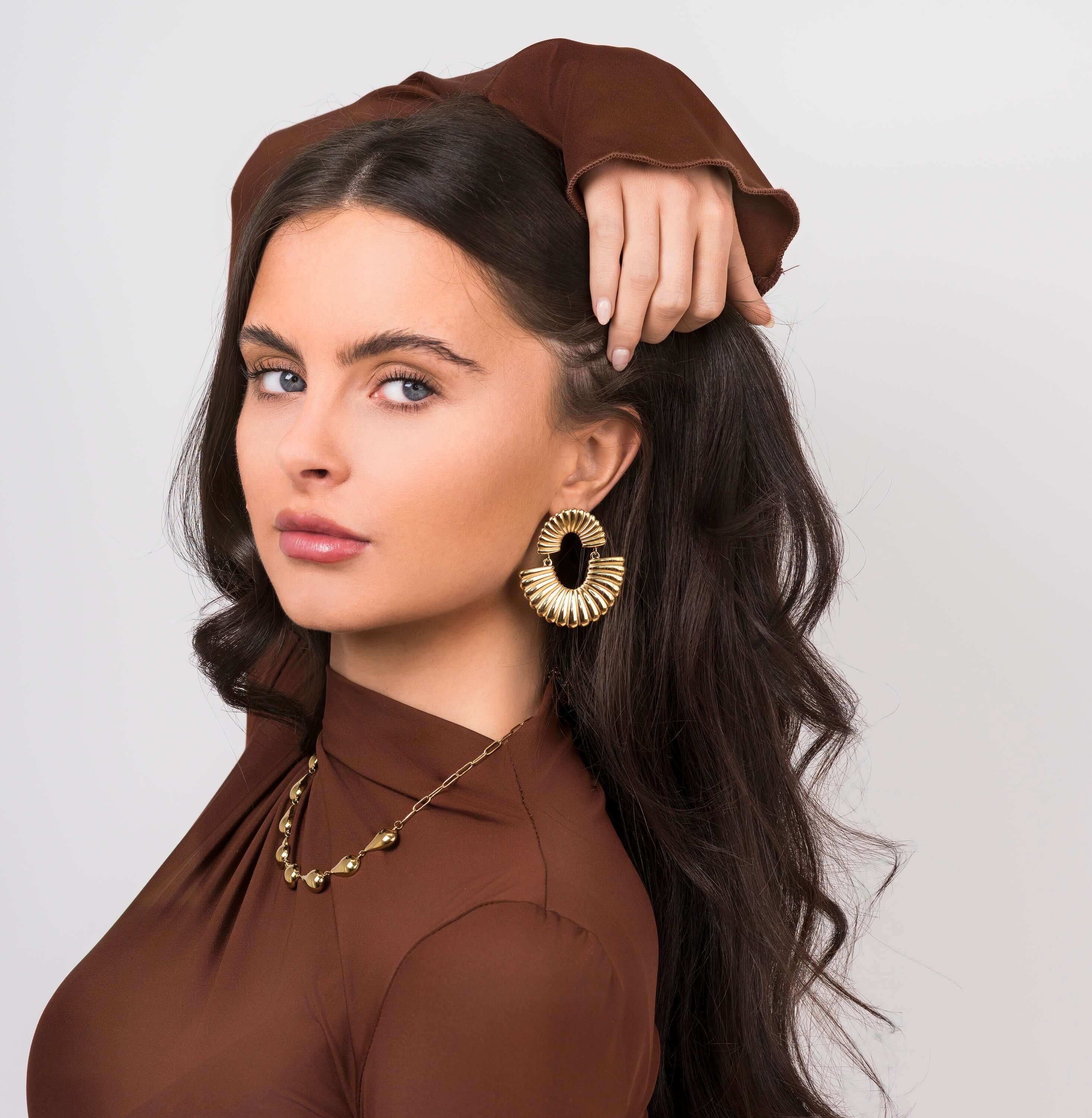 Model showcasing Layali Sculpted Fan Drop Earrings by ARIIRA, featuring a bold, lightweight design and a stunning silhouette.