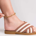 Lina elongated link chain gold anklet on a styled foot wearing a striped slide, adding elegance and shine.
