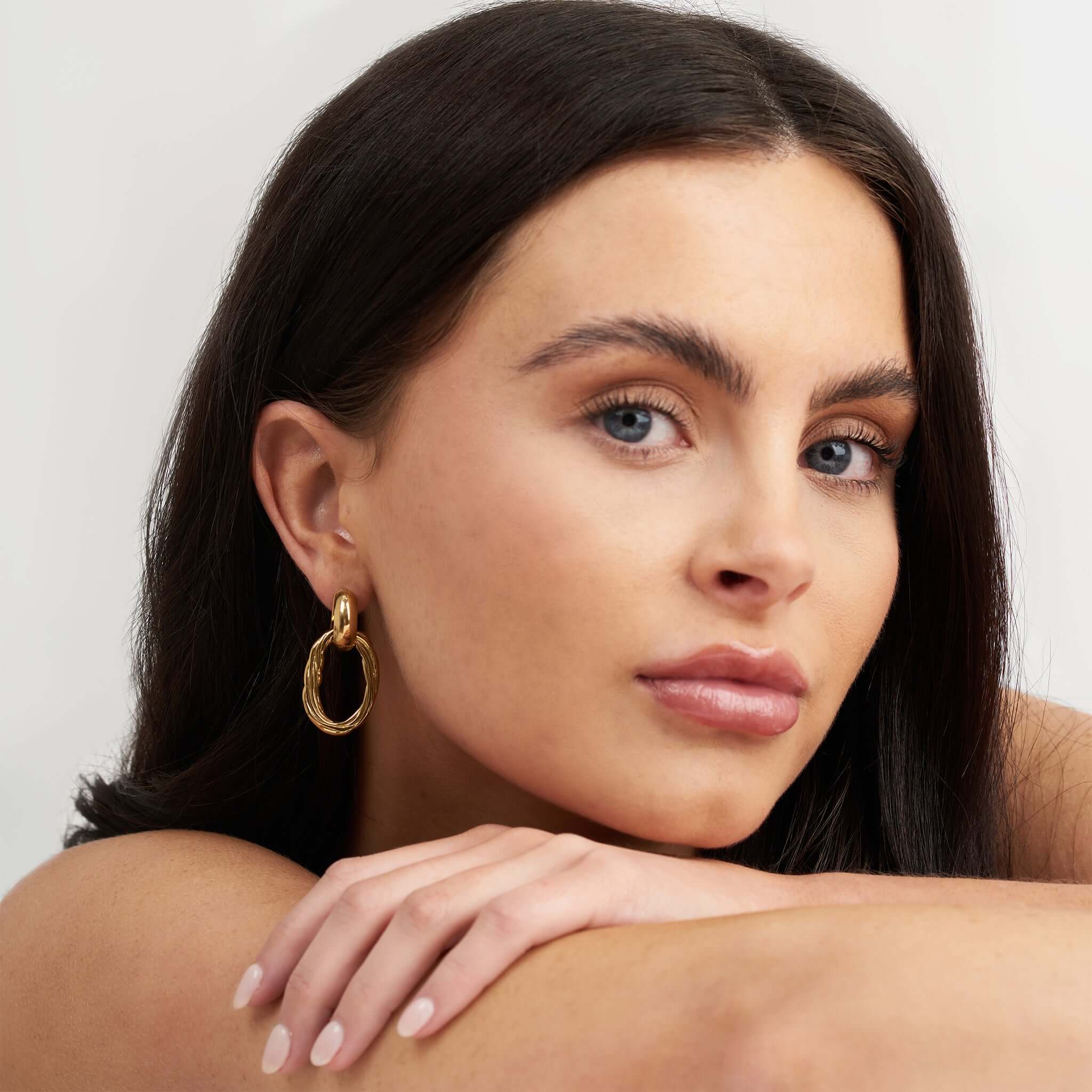 Model wearing ARIIRA Alina Linked Gold Drop Earrings, showcasing their elegant interlocked design.