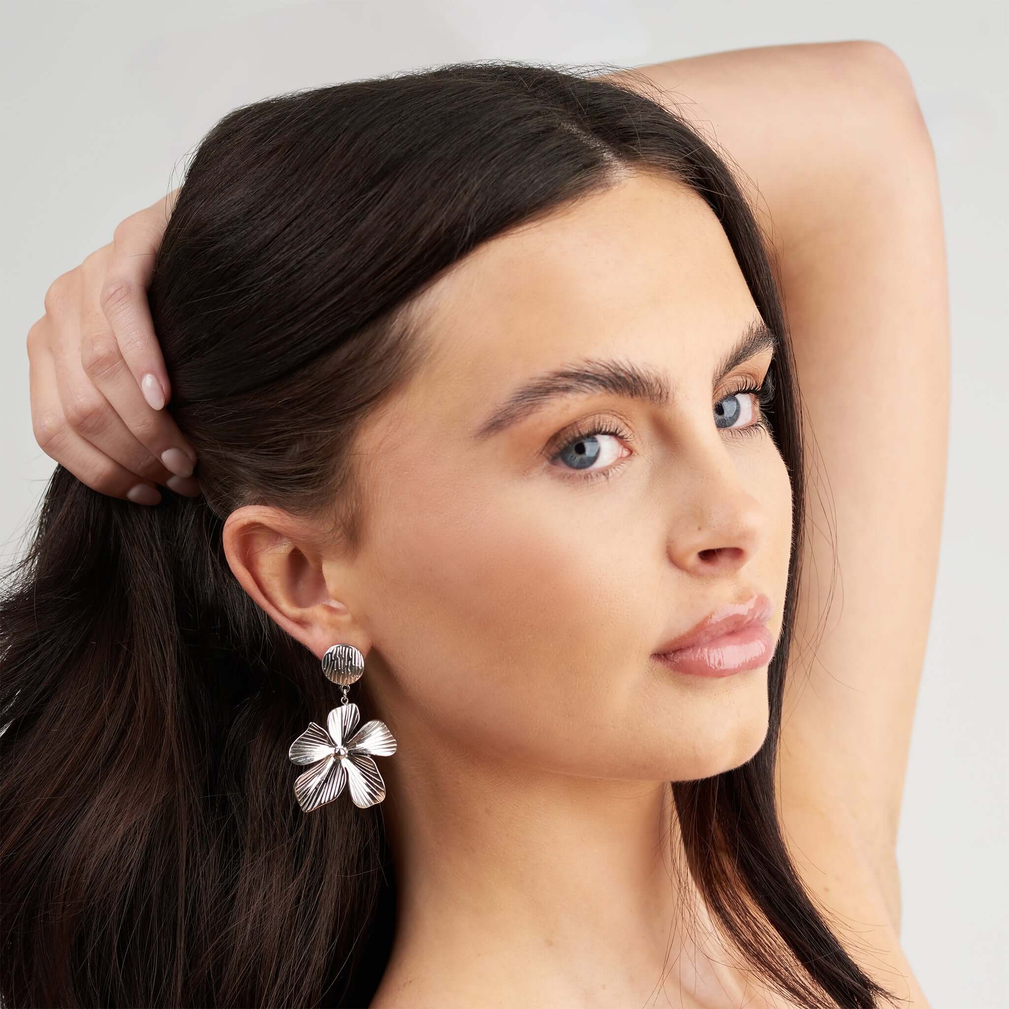 Malia Bloom Statement Earrings by ARIIRA, featuring textured silver petals reflecting light beautifully.