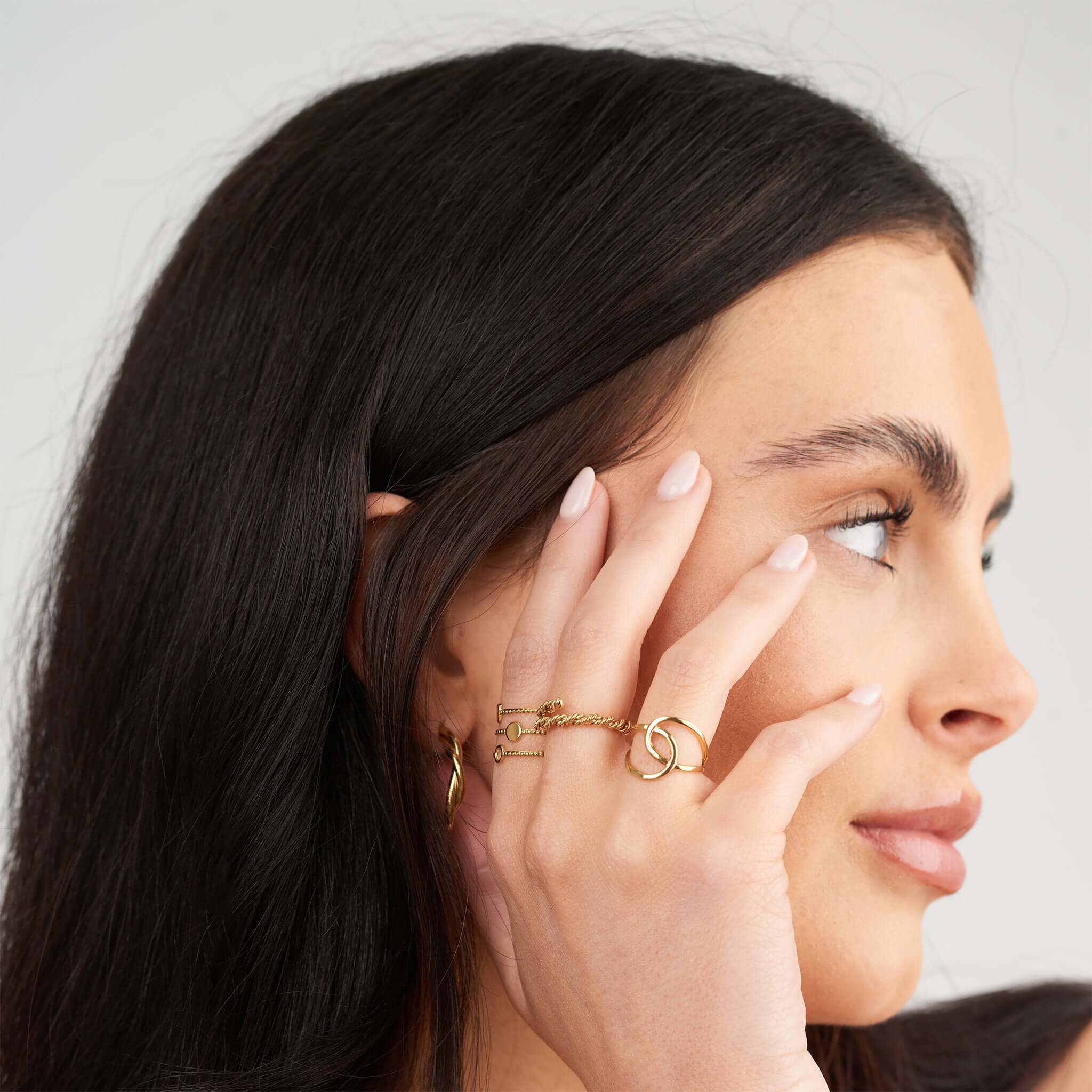 Close-up of a woman wearing the Amina Swirl Statement Ring by ARIIRA, showcasing its elegant design and fluid curves.